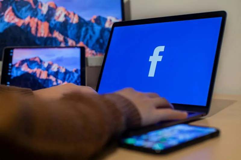 Laptop met Facebook en een smartphone op een bureau