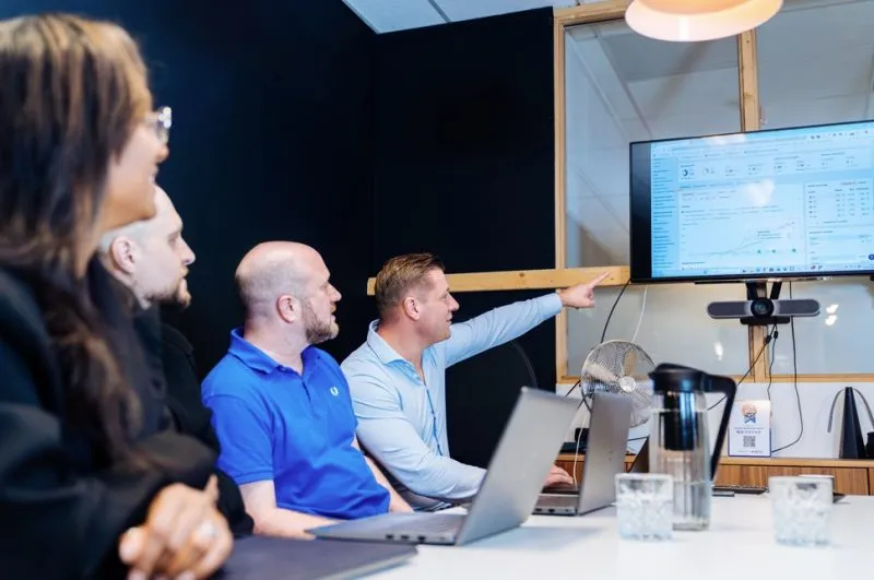 Het team van ROXTAR bespreekt campagneresultaten op een scherm