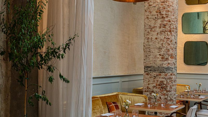 Restaurantinterieur met gedekte tafels en een bakstenen zuil