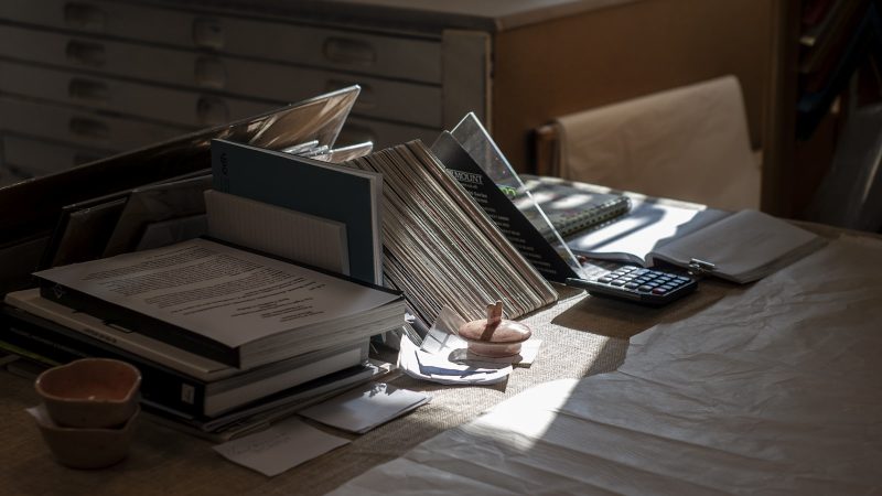 Bureau met dossiers, papieren en een rekenmachine