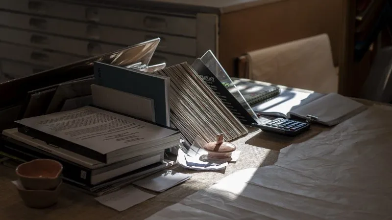 Bureau met dossiers, papieren en een rekenmachine