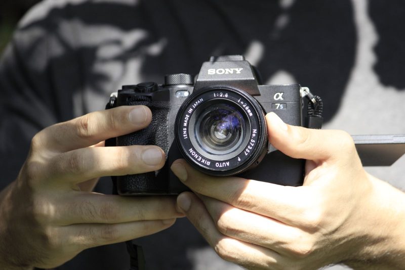 Handen aan een camera, beeld bij online marketing voor fotografen