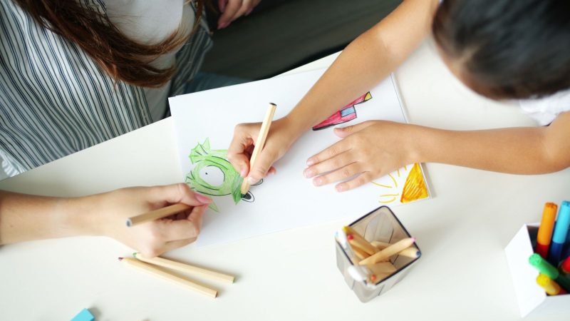 Kind werkt met begeleiding aan een oefening, beeld bij online marketing voor logopedisten