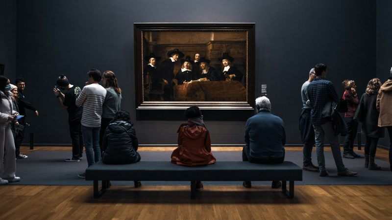 Bezoekers bekijken een schilderij in een museum