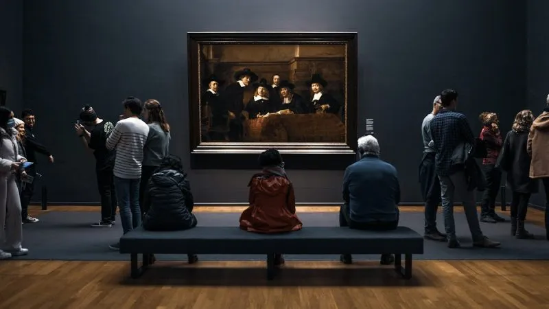 Bezoekers bekijken een schilderij in een museum